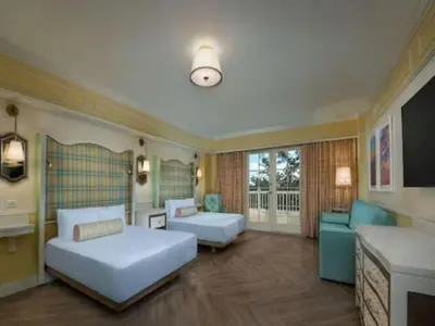a hotel room with two beds and a couch at Disney's Boardwalk Inn in Orlando