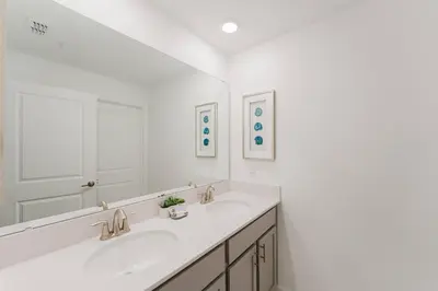 a white bathroom with two sinks and a mirror at 3017 SL new 11 guests heat pool BBQ near Disney in Kissimmee