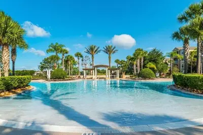a large swimming pool with palm trees in a resort at 2541 - Casa 3 Quartos/3 Banheiros | Piscina Privativa & Resort in Orlando