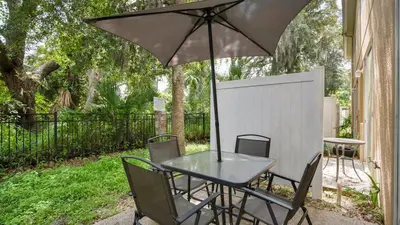a table and chairs with an umbrella on a patio at Family Friendly Townhome Near Attractions in Orlando