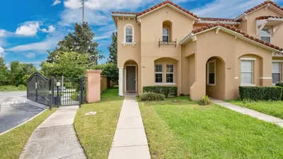 a house with a gate in front of a yard at Quiet Corner Gem in Gated Crestwynd Bay in Orlando