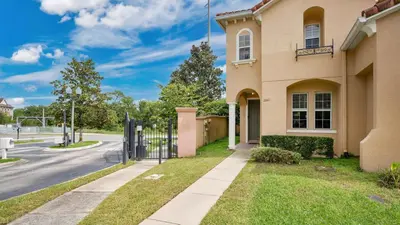 a house with a gate in front of a street at Quiet Corner Gem in Gated Crestwynd Bay in Orlando