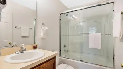 a bathroom with a sink and a glass shower at Quiet Corner Gem in Gated Crestwynd Bay in Orlando