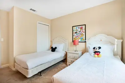 a bedroom with two beds and a teddy bear sitting on the bed at Relaxing Getaway in Emerald Island Near Disney in Kissimmee