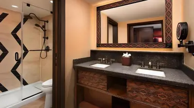 a bathroom with a sink and a toilet and a mirror at Disney's Animal Kingdom Lodge in Orlando