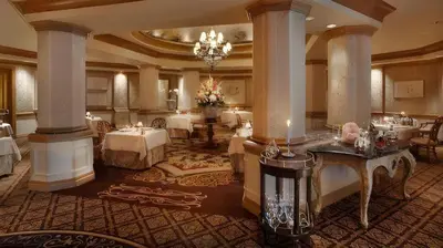 a hotel lobby with tables and chairs and a chandelier at Disney's Grand Floridian Resort And Spa in Orlando