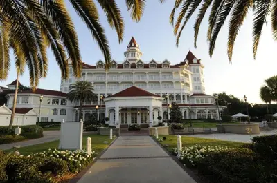 a large white building with palm trees in front of it at Disney's Grand Floridian Resort And Spa in Orlando