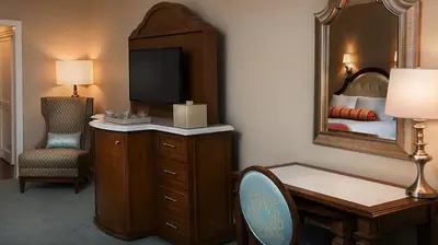a hotel room with a desk and a mirror at Disney's Grand Floridian Resort And Spa in Orlando
