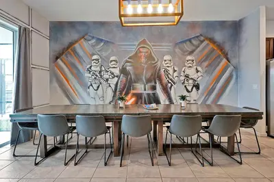 a dining room with a table with a painting on the wall at Luxury 12-BR Villa w/ Pool & Resort Amenities Near Disney in Kissimmee