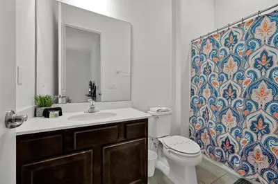 a bathroom with a sink and a toilet and a shower curtain at Luxury 12-BR Villa w/ Pool & Resort Amenities Near Disney in Kissimmee