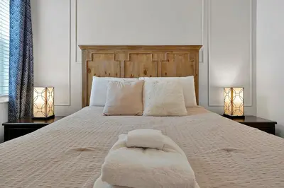 a bedroom with a bed with a white bedspread and two lamps at Luxury 12-BR Villa w/ Pool & Resort Amenities Near Disney in Kissimmee