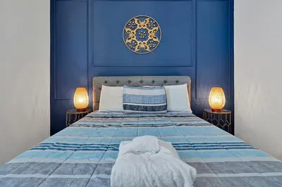 a blue bedroom with a bed with two lamps at Luxury 12-BR Villa w/ Pool & Resort Amenities Near Disney in Kissimmee