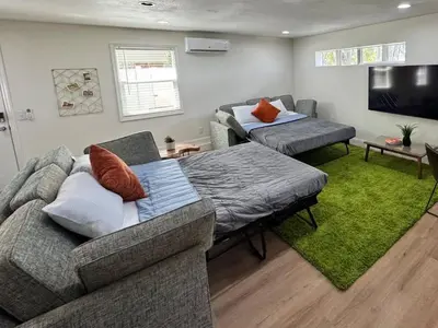 a living room with a couch and a tv at StylishAptWtrGrdnOppLake&Prk&Yrd in Orlando