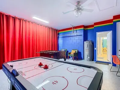 a ping pong table in a room with red curtains at T8134-Windsor Palms Resort Pool and Spa Near Disney in Kissimmee
