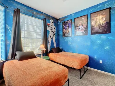 a bedroom with two beds and a blue wall at C2821-403-Windsor Hills Resort-Free Water Park-2 Miles to Disney in Orlando