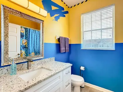 a bathroom with a sink and a toilet and a mirror at C2821-403-Windsor Hills Resort-Free Water Park-2 Miles to Disney in Orlando