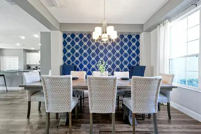 a dining room with a table and chairs at Waterfront Villa showcasing a theater, games room, and a private pool in Kissimmee
