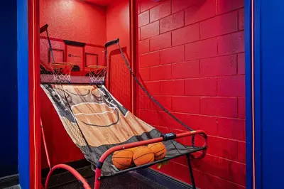 a basketball hoop with a bench in a red wall at 6Q/4B | Piscina Privativa | Sala de Jogos Avengers in Orlando