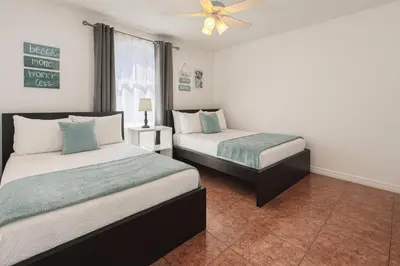 a bedroom with two beds and a ceiling fan at 3Q/2B 15 min até a Disney, Piscina, Indian Wells in Kissimmee