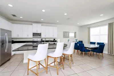 a kitchen with white cabinets and a table and chairs at Regal Home With Private Pool Near Disney With Waterpark & Resort Access At Encore Resort - 7727Ff in Kissimmee