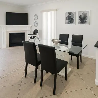a living room with a table and chairs and a television at 3Q/2B Perto da DISNEY, Piscina Privativa in Kissimmee