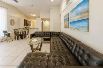 a living room with a leather couch and a table at 3Q/2B Perto da DISNEY ☆ Piscina Priv. in Kissimmee