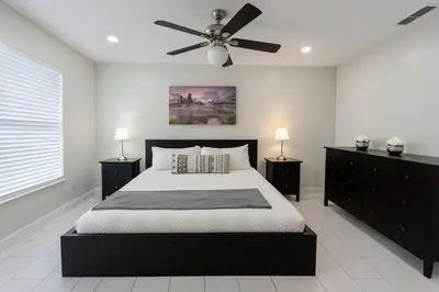 a bedroom with a black bed and a ceiling fan at 3Q/2B Perto da DISNEY ☆ Piscina Priv. in Kissimmee