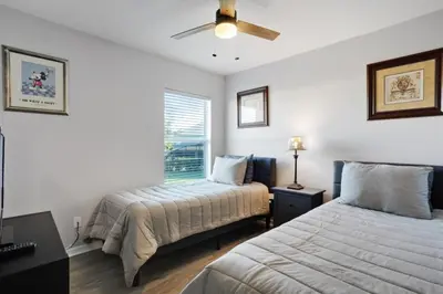 a bedroom with two beds and a ceiling fan at Six Bedroom Disney Home Lanai Screened Pool & Spa villa in Kissimmee
