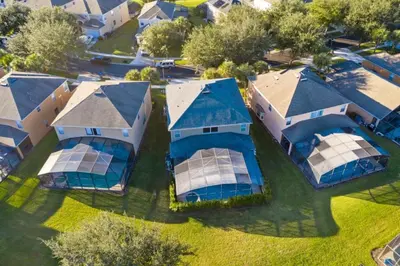 an aerial view of a home with solar panels on the roofs at Six Bedroom Disney Home Lanai Screened Pool & Spa villa in Kissimmee