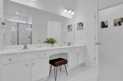 a white bathroom with two sinks and a stool at Luxury Home - ALL the extras - Sleeps 39 in Kissimmee