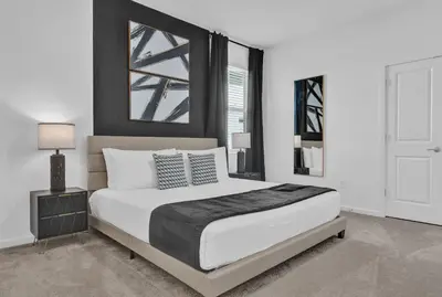 a white bedroom with a large bed and a window at Luxury Home - ALL the extras - Sleeps 39 in Kissimmee
