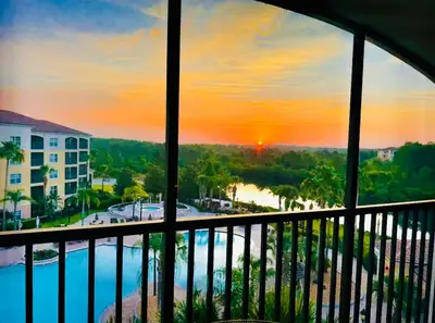 a view from the balcony of a resort with a sunset at Luxurious & Epic Condo in heart of Orlando in Orlando