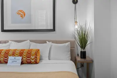 a bed with white pillows and a picture on the wall at Banana Leaf Villa in Orlando