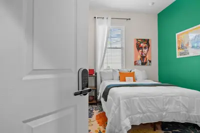 a bedroom with a bed and a green wall at Banana Leaf Villa in Orlando