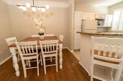 a kitchen and dining room with a table and chairs at Magical Themed 3BR Townhouse Near the Parks in Kissimmee
