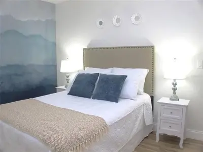 a bedroom with a bed with two night stands and two lamps at Elegance House in Kissimmee