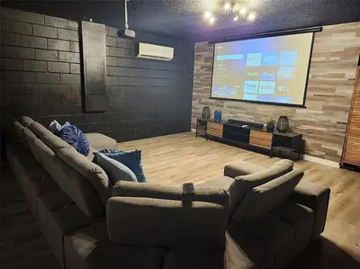 a living room with couches and a large screen at Elegance House in Kissimmee