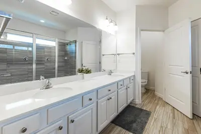 a bathroom with two sinks and a large mirror at Fantastic 5 BD Pool Near Disney Resort Perks in Kissimmee