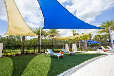 a patio with blue and yellow umbrellas and chairs at Fantastic 5 BD Pool Near Disney Resort Perks in Kissimmee