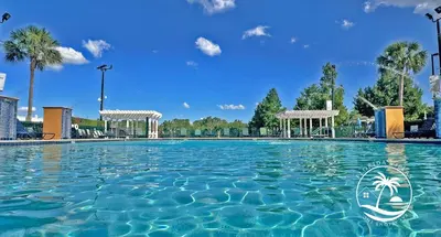 a swimming pool at a resort with blue skies and palm trees at Standard four beds Villas Seven Dwrafs - Close to Disney in Kissimmee