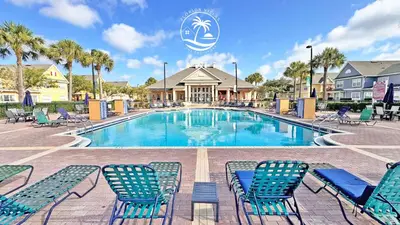 a swimming pool with blue chairs and palm trees at Standard four beds Villas Seven Dwrafs - Close to Disney in Kissimmee