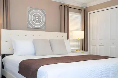 a bedroom with a large white bed with white pillows at Villa Smile - 4Q/3B Storey Lake *Casa Luxuosa* in Kissimmee