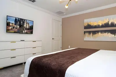 a white bedroom with a bed and a dresser at Villa Smile - 4Q/3B Storey Lake *Casa Luxuosa* in Kissimmee