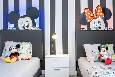 a bedroom with two twin beds with mickey mouse headboards at Villa Smile - 4Q/3B Storey Lake *Casa Luxuosa* in Kissimmee