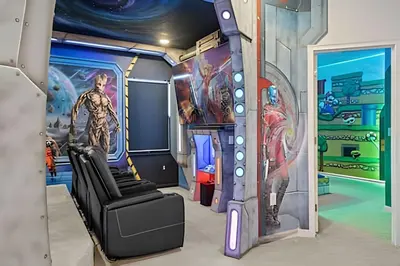 a room with a marvel themed room with a couch and a mural at Casa 6Q Luxo c/ Piscina, Game Room e Cinema in Orlando
