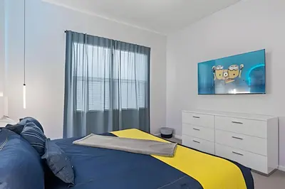 a bedroom with a blue and yellow bed and a dresser at Casa 6Q Luxo c/ Piscina, Game Room e Cinema in Orlando