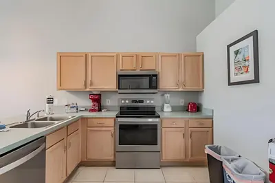 a kitchen with wooden cabinets and a stove top oven at 4Q/2B Seu Refúgio Perto da Disney in Kissimmee