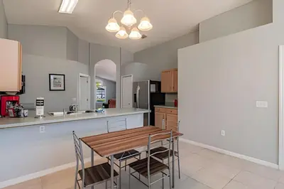 a kitchen with a wooden table and chairs at 4Q/2B Seu Refúgio Perto da Disney in Kissimmee