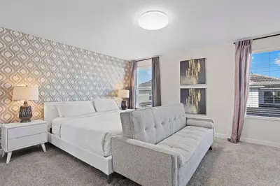 a bedroom with a white bed and a couch at 4718 Sleepy Hollow Drive in Kissimmee