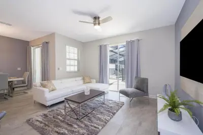 a living room with a white couch and a table at 4 BD 3 BA Private Pool Storey Lake 4832 in Kissimmee
